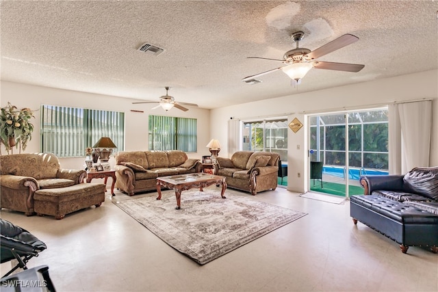 living room featuring ceiling fan and a textured ceiling