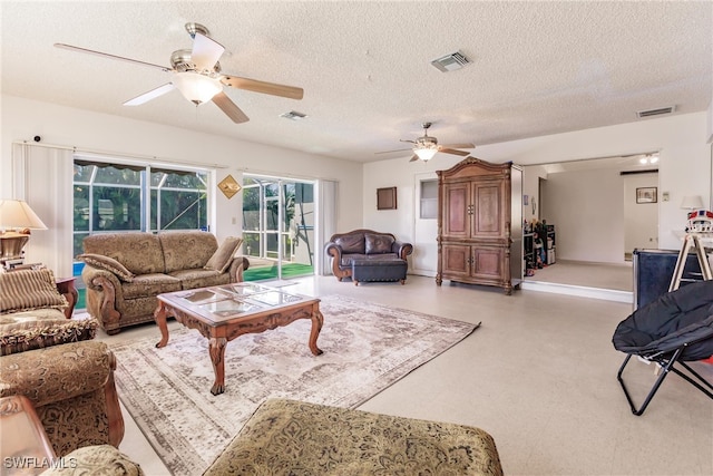 living room featuring ceiling fan and a textured ceiling