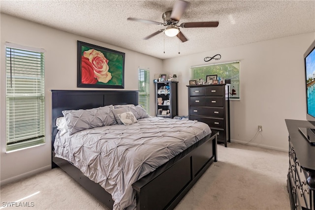 carpeted bedroom featuring ceiling fan and a textured ceiling