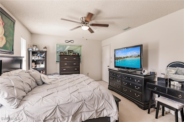 bedroom featuring ceiling fan, a textured ceiling, and light colored carpet