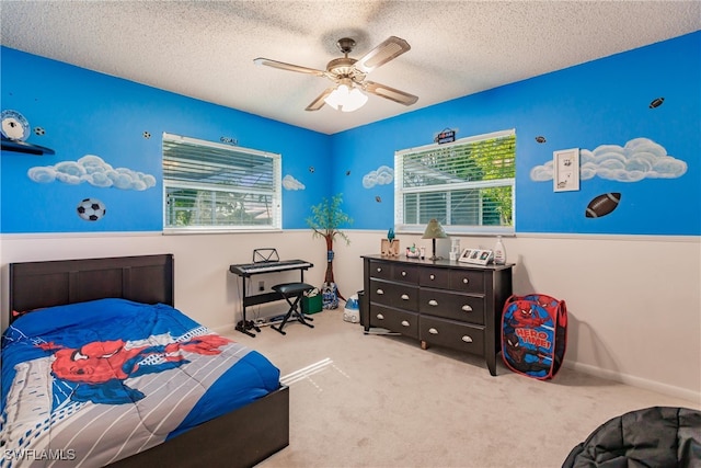 bedroom featuring light colored carpet, ceiling fan, and a textured ceiling