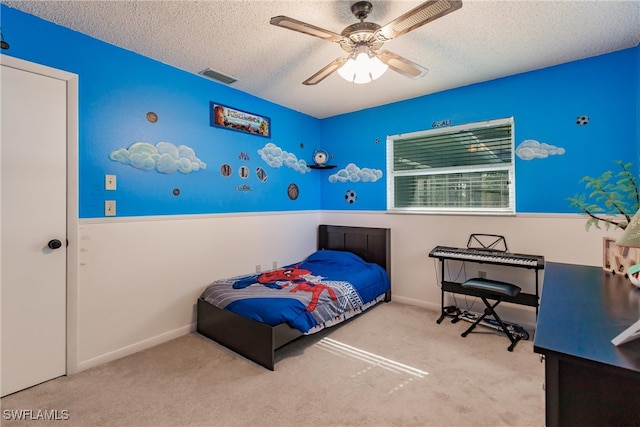 bedroom with a textured ceiling, light colored carpet, and ceiling fan