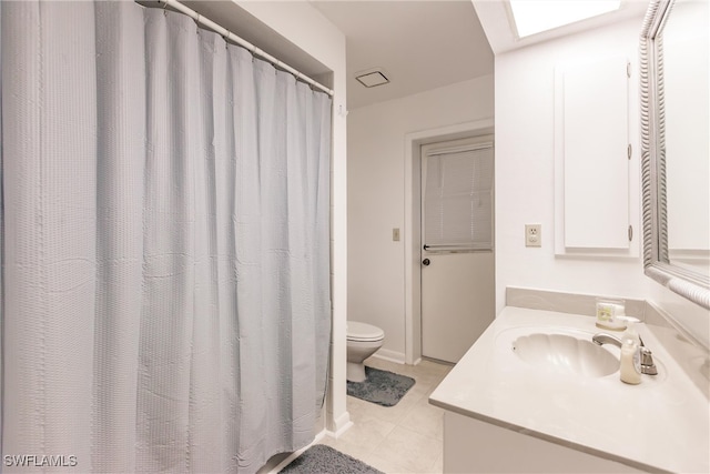 bathroom with tile patterned flooring, a shower with curtain, toilet, a skylight, and vanity