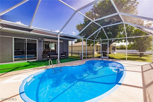 view of swimming pool with a patio, a lanai, and a lawn