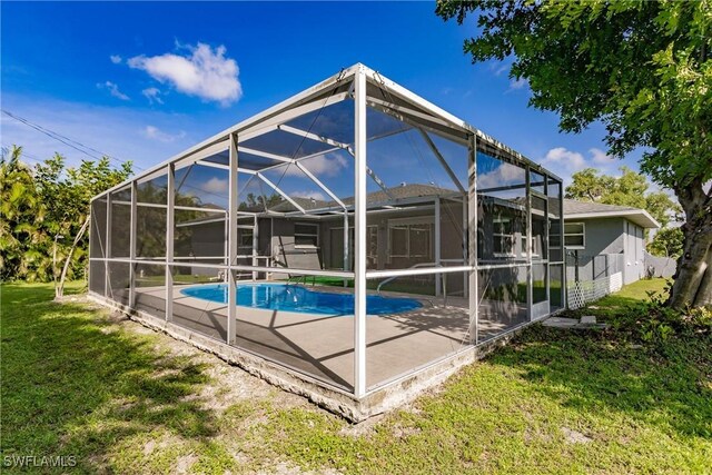 view of pool featuring a yard, glass enclosure, and a patio area