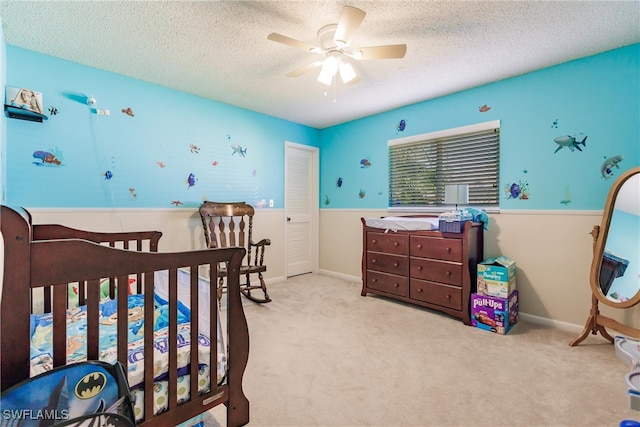 carpeted bedroom with ceiling fan and a textured ceiling