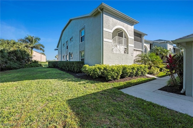 view of property exterior with a lawn and stucco siding