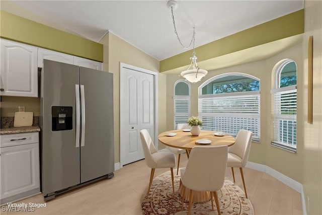 dining area featuring lofted ceiling and light hardwood / wood-style floors