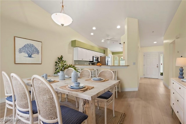 dining area featuring light hardwood / wood-style floors, ceiling fan, and lofted ceiling