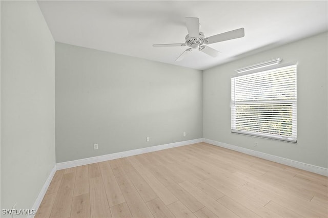 unfurnished room with light wood-style floors, baseboards, and a ceiling fan