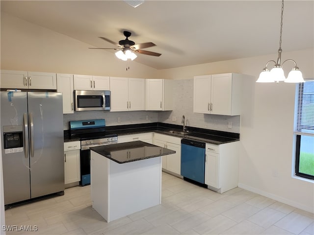 kitchen featuring a center island, vaulted ceiling, ceiling fan with notable chandelier, appliances with stainless steel finishes, and pendant lighting