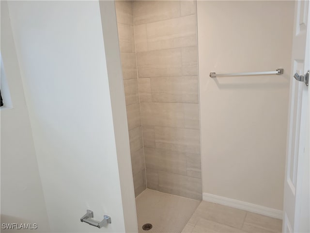 bathroom with tiled shower and tile patterned floors