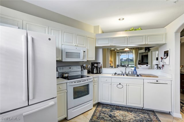 kitchen with white cabinets, white appliances, light tile patterned flooring, and sink