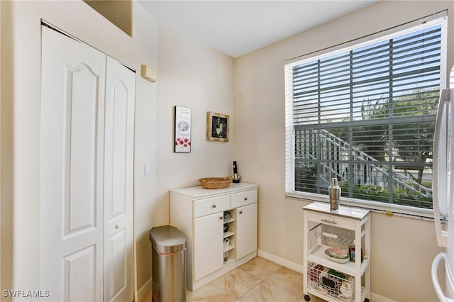 interior space with a wealth of natural light, baseboards, and light tile patterned flooring