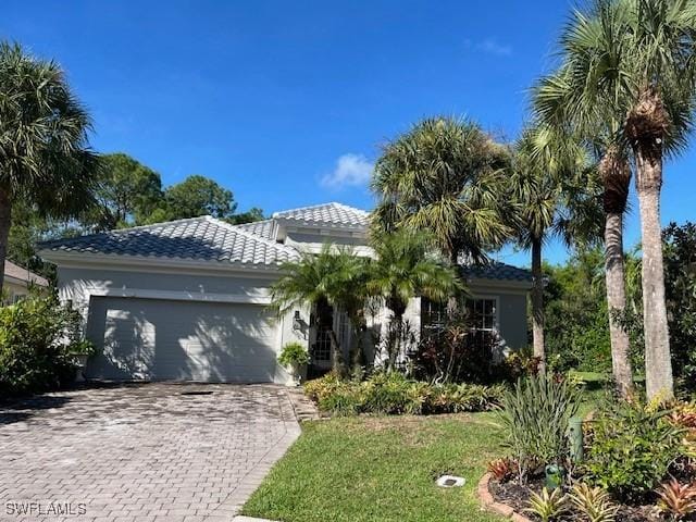 view of front of home with a garage and a front lawn