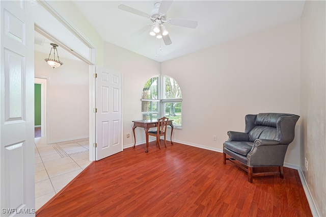 living area with light hardwood / wood-style floors and ceiling fan