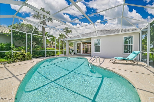 view of swimming pool featuring a patio and glass enclosure