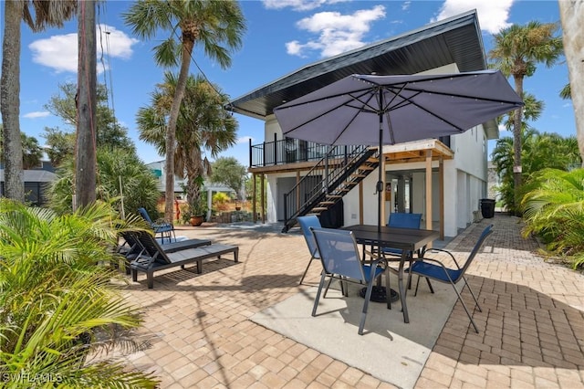 view of patio / terrace featuring outdoor dining space and stairway