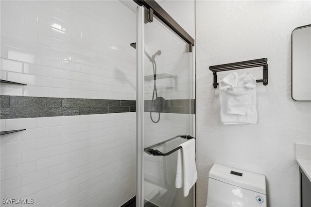 bathroom with toilet, a shower stall, and vanity