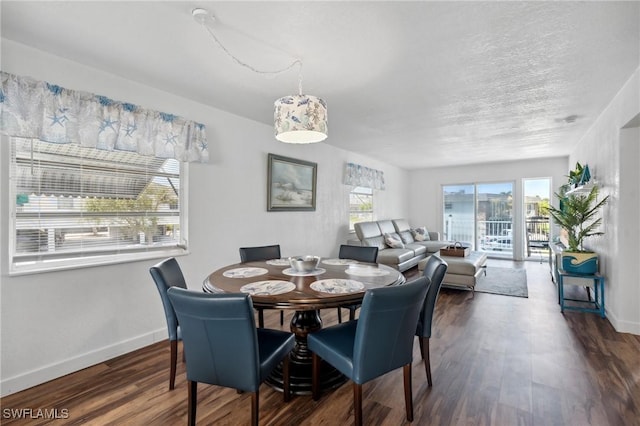 dining area with dark wood-style floors, a textured ceiling, and baseboards