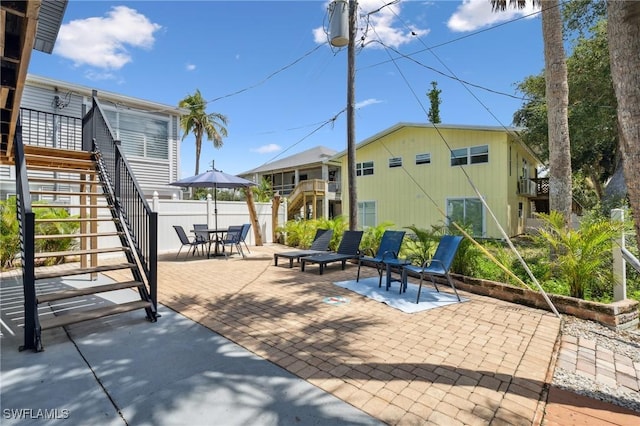 view of patio with fence and stairs