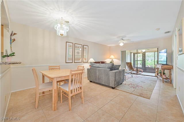 dining space featuring french doors, ceiling fan with notable chandelier, and light tile patterned flooring