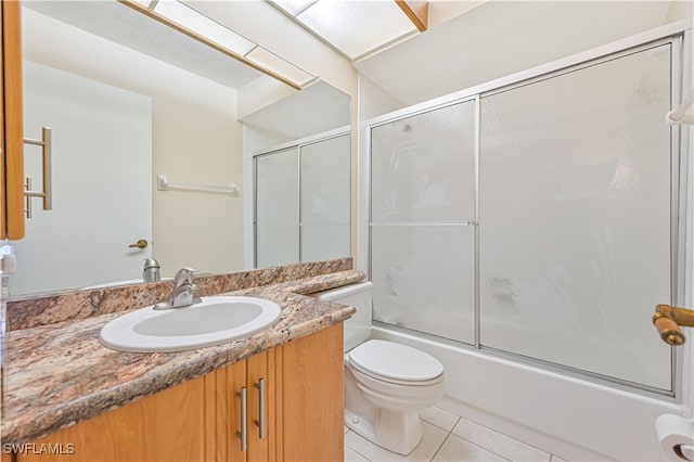 full bathroom with tile patterned flooring, vanity, toilet, and shower / bath combination with glass door