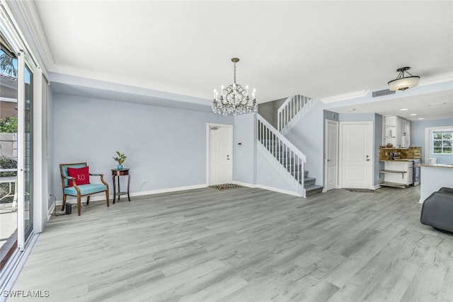 interior space with a notable chandelier, visible vents, baseboards, stairs, and light wood-style floors