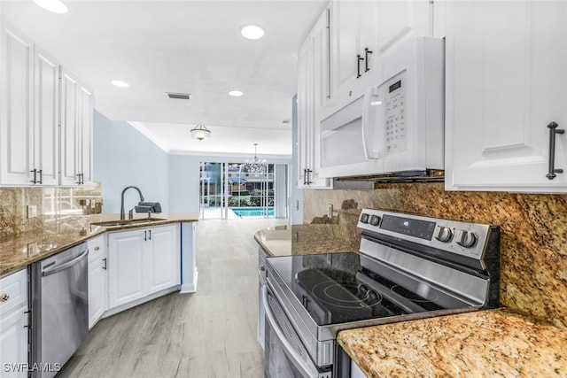 kitchen featuring light wood-style flooring, a sink, visible vents, white cabinets, and appliances with stainless steel finishes