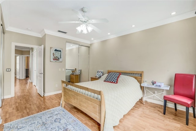 bedroom featuring visible vents, baseboards, ornamental molding, a closet, and light wood-type flooring