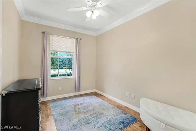 interior space featuring ornamental molding, light wood-type flooring, baseboards, and a ceiling fan