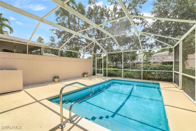 outdoor pool featuring glass enclosure and a patio area