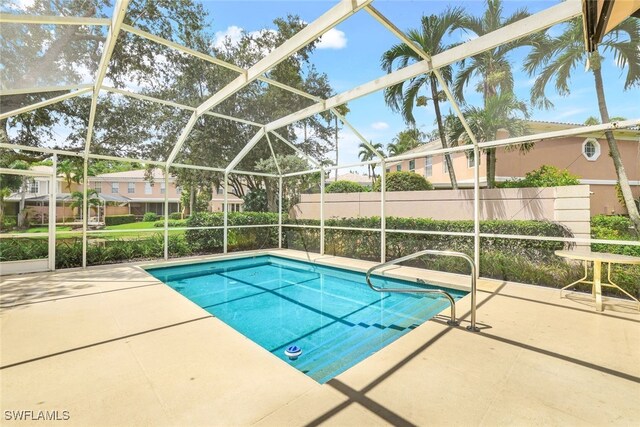 view of swimming pool featuring a fenced in pool, glass enclosure, and a patio area