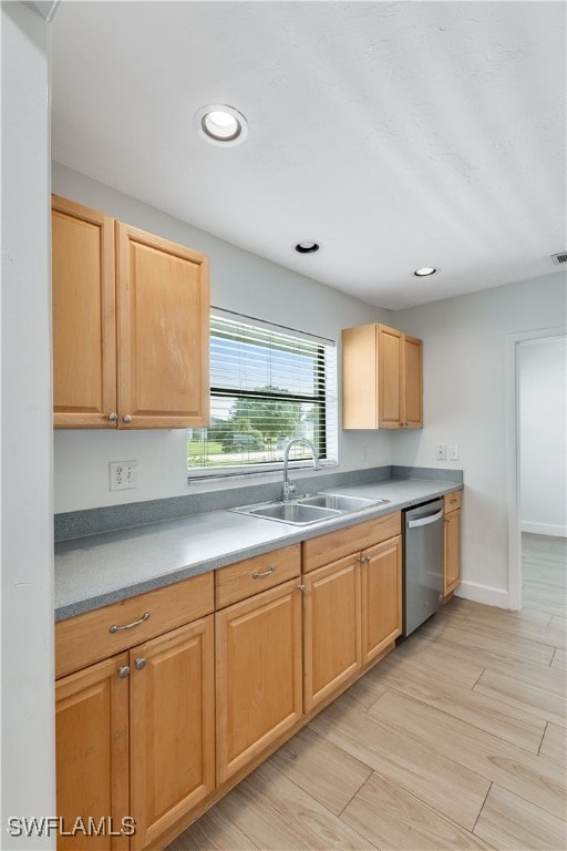 kitchen with light wood-type flooring, stainless steel dishwasher, and sink