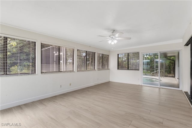 spare room with ceiling fan, plenty of natural light, and light hardwood / wood-style floors