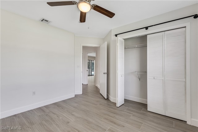 unfurnished bedroom with light hardwood / wood-style flooring, ceiling fan, and a closet