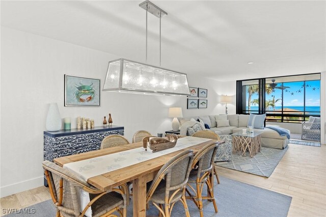 2777 W Gulf Dr Unit 109, Sanibel, FL 33957 - dining space featuring light wood-type flooring, floor to ceiling windows, and baseboards