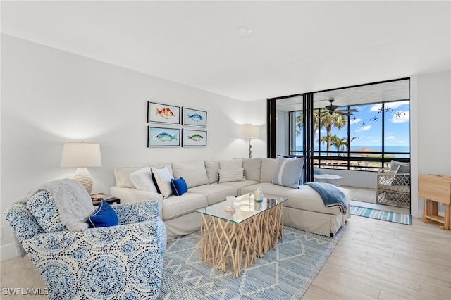 living room with expansive windows and light hardwood / wood-style flooring