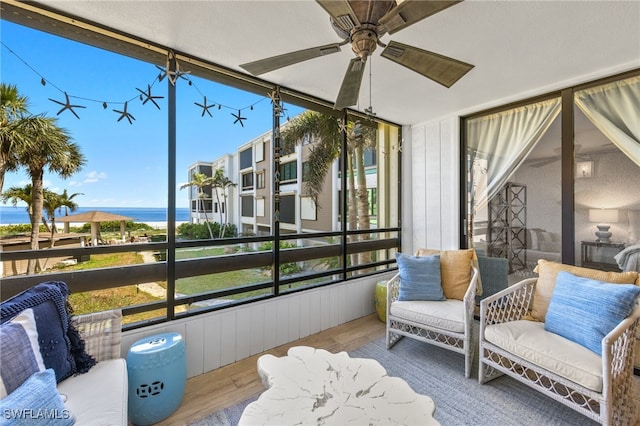 sunroom / solarium featuring a water view, ceiling fan, and a healthy amount of sunlight