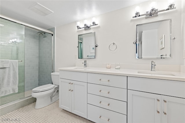 bathroom featuring a shower with door, vanity, toilet, and tile patterned flooring