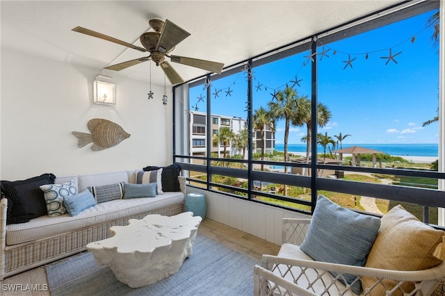 sunroom featuring a water view and ceiling fan