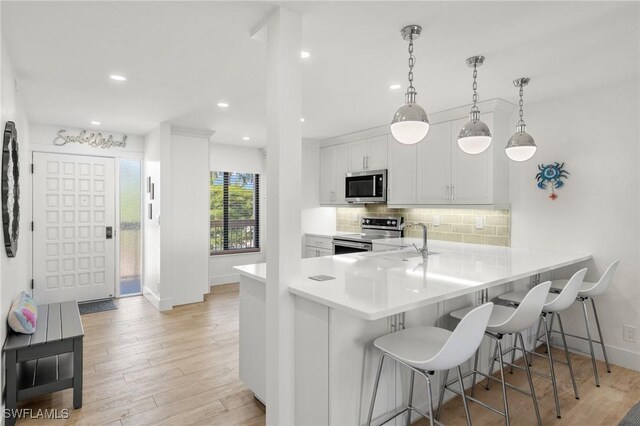 2777 W Gulf Dr Unit 109, Sanibel, FL 33957 - kitchen featuring stainless steel appliances, a sink, tasteful backsplash, light wood-type flooring, and recessed lighting