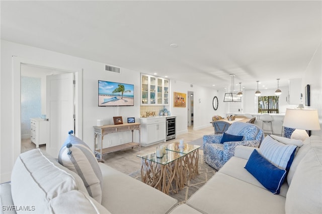 living room featuring wine cooler and light hardwood / wood-style flooring