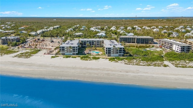 birds eye view of property with a water view and a beach view