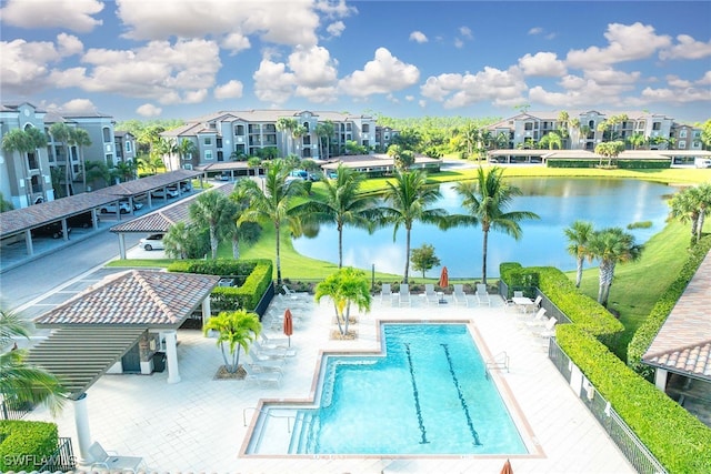 view of swimming pool featuring a water view and a patio area