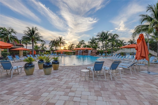 pool at dusk featuring a patio area