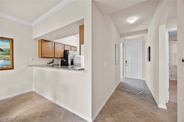 corridor featuring ornamental molding and light tile patterned flooring