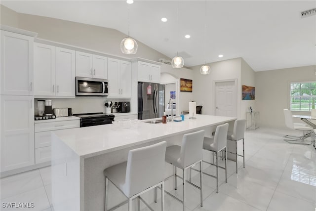 kitchen with a center island with sink, pendant lighting, a kitchen bar, stainless steel appliances, and white cabinets