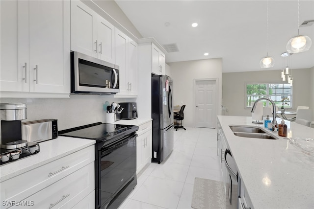 kitchen with light stone countertops, pendant lighting, appliances with stainless steel finishes, sink, and white cabinetry