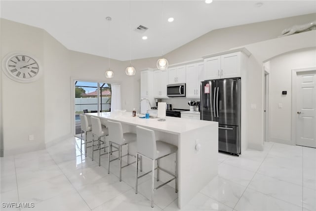 kitchen with pendant lighting, white cabinetry, stainless steel appliances, a breakfast bar area, and a center island with sink